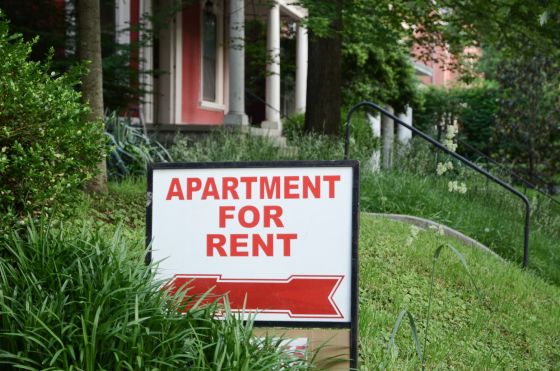 Apartment For Rent sign in a front yard