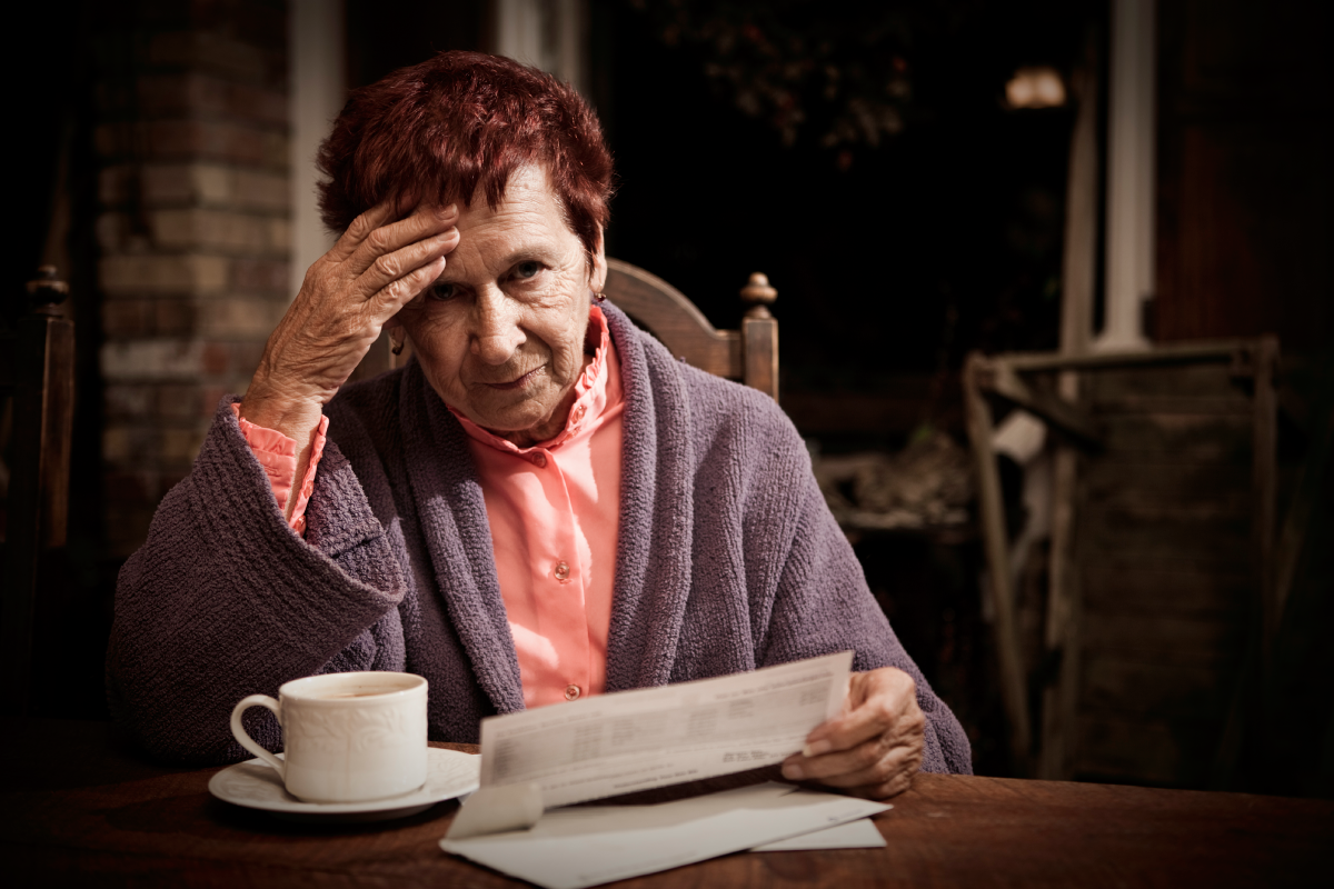 Debt stressed older woman looking at a bill